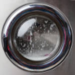 Closeup of washing machine with foam on front load
